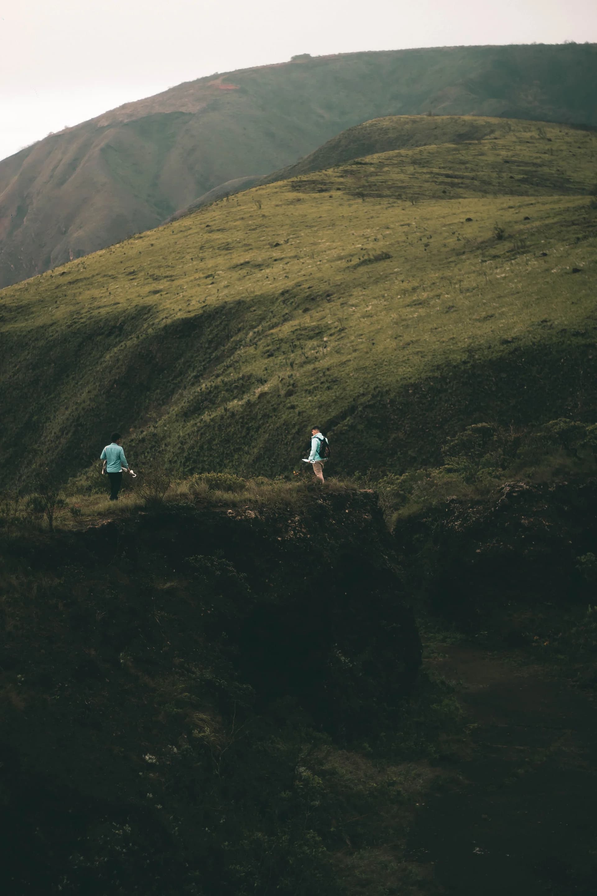 Two friends hiking through green mountain scenery